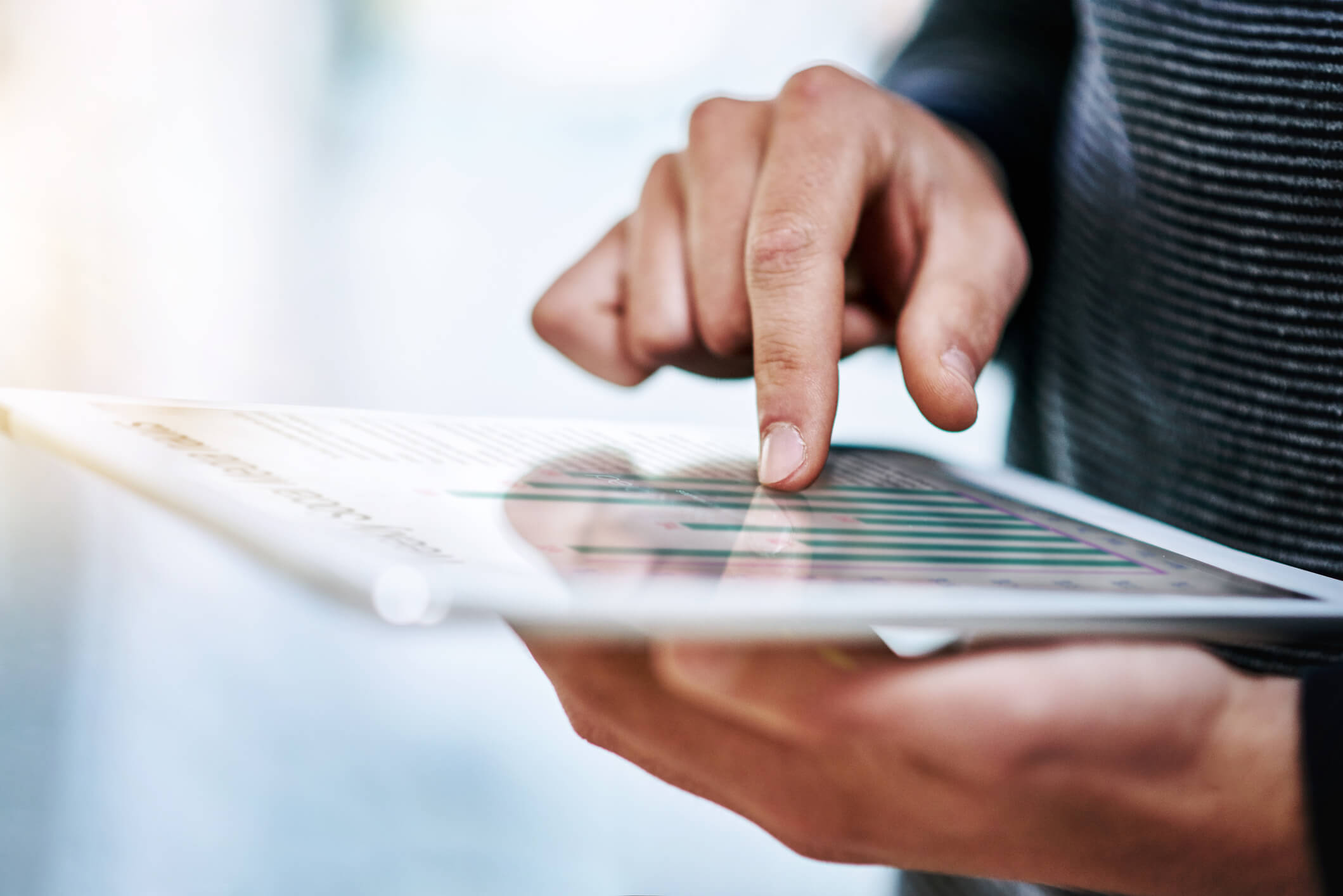 Closeup shot of an unidentifiable businessman working on a digital tablet in an office